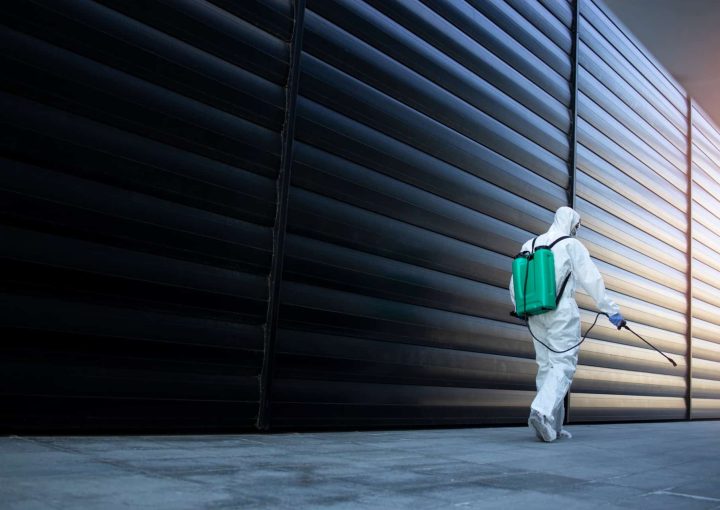 Man sanitising an tall aluminium fence