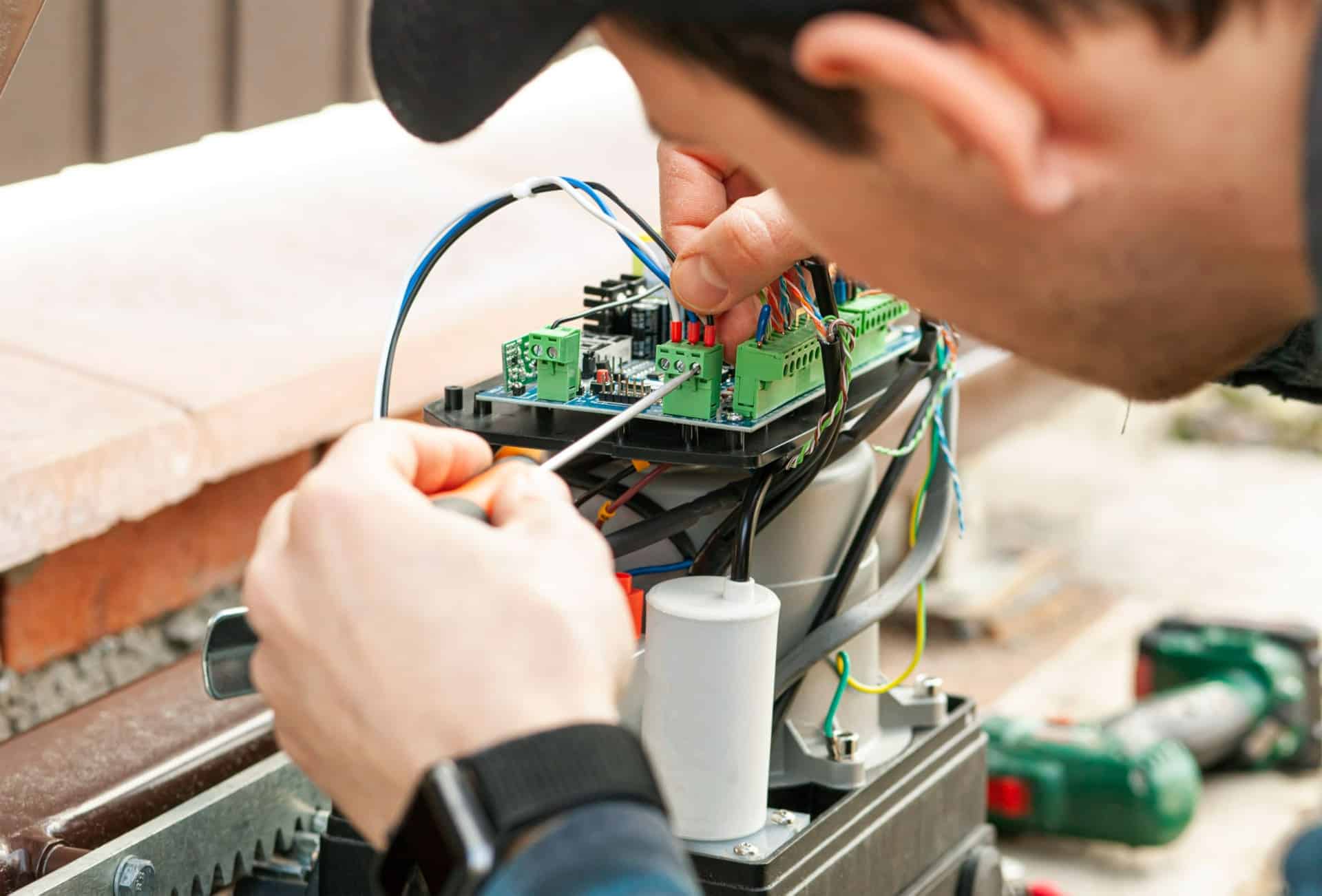 Technician repairing an automatic gate opener