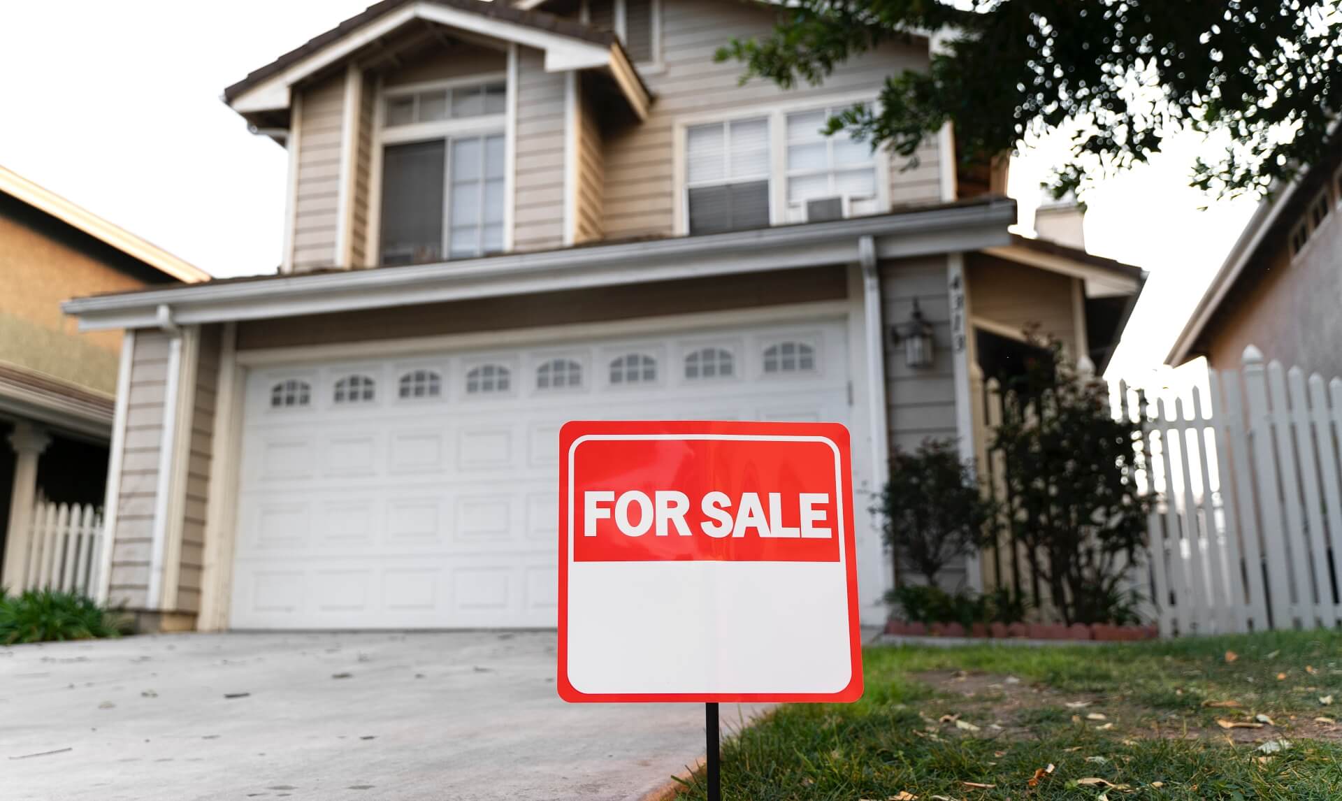 2 story house with for sale sign in front yard